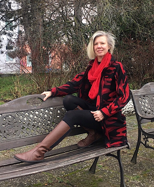 junge Frau mit schwarz weißer Jacke und rotem Schal auf einer Bank sitzend im Jahresrückblick 2021