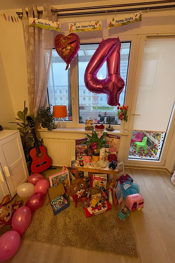 rosa Geburtstagsballon und Geburtstagstisch einer Vierjährigen