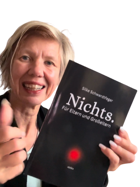 blonde Frau zeigt freudig das Buch "Nichts" und hält den Daumen hoch