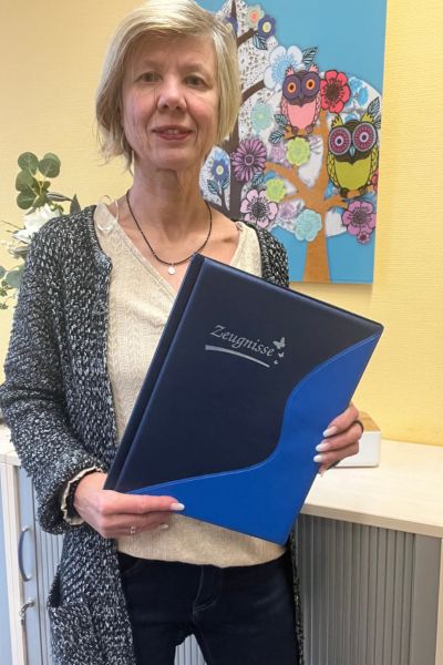 Monatsrückblick Januar 2025: blonde Frau mit einer blauen Zeugnismappe in der Hand