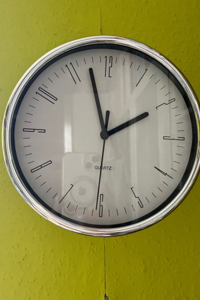 Uhrzeit lernen mit Kindern: eine analoge Uhr hängt an der Wand