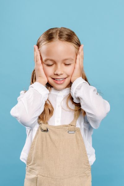 Wie Kinder besser zuhören: Mädchen halt sich mit den Händen beide Ohren zu