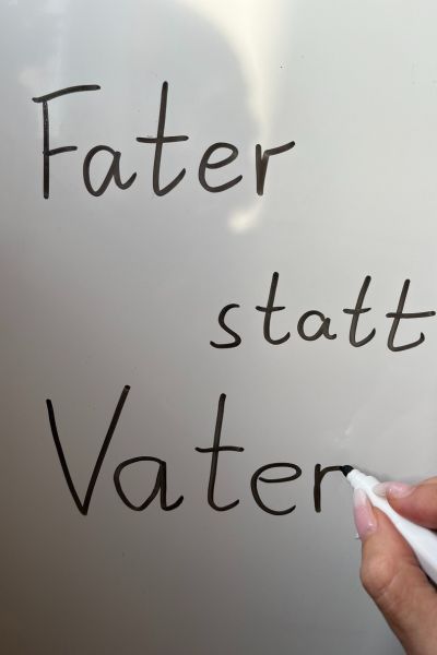 Rechtschreibfehler: Fater mit F, statt Vater mit V steht in schwarzen Buchstaben auf einem weißen Flipchart 