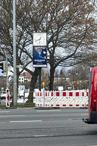 Uhrzeit lernen mit Kindern: Uhr steht im öffentlichen Raum an einer Kreuzung