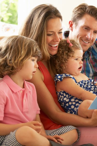 Glaubenssatz gute Noten Erfolg: Eine Familie sitzt zusammen, Eltern und Kinder; Sie freuen sich