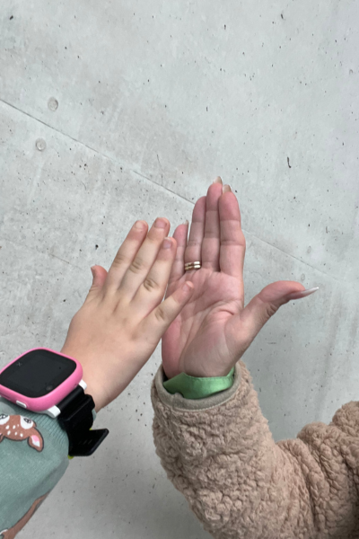 100 kleine Dinge Familienalltag; Hand einer erwachsenen Frau und Kinderhand schlagen ein