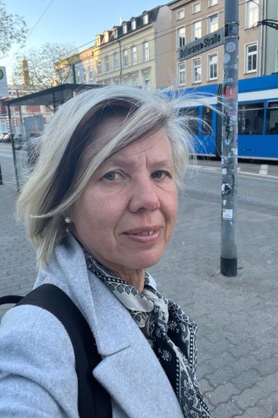 12 von 12 im Mai - blonde Frau am frühen Morgen an der Straßenbahnhaltestelle, im Hintergrund eine blaue Straßenbahn