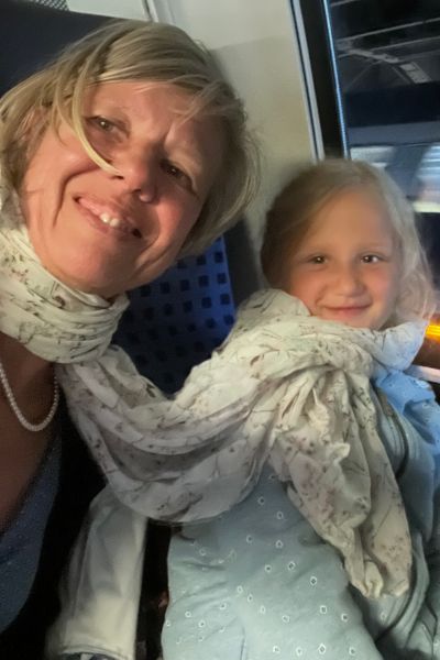 100 Dinge im Familienalltag: blonde Frau und blondes Mädchen sind mit einem Schal verbunden