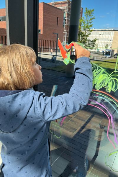 100 Dinge für die ich dankbar bin: blondes Mädchen zeichnet ein Einhorn an die Fensterscheibe