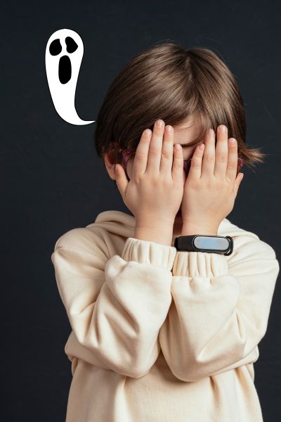 EMDR bei Angst und Zwängen; Kind vor schwarzem Hintergrund hält die Hände vor das Gesicht