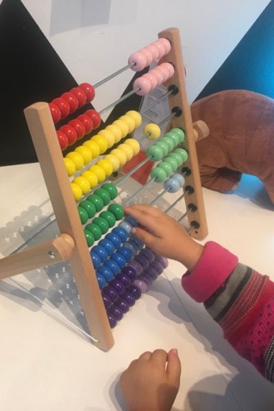 Frühkindliche Reflexe integrieren; Kind rechnet mit dem Abacus