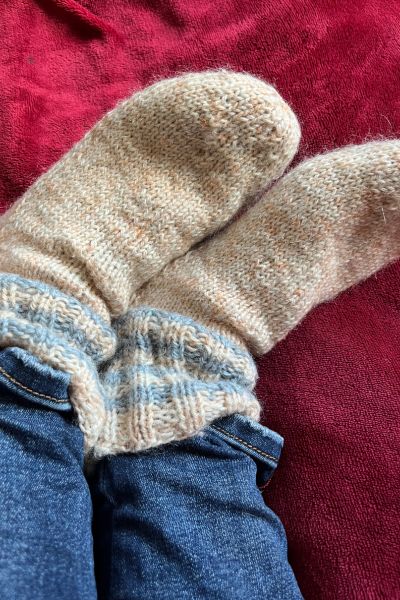12 von 12; Füße in gelben gestrickten Socken liegen auf einer roten Decke