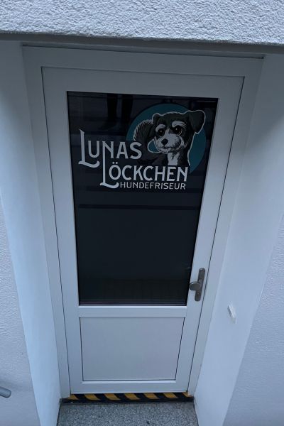 12 von 12; weiße Tür mit Glasfenster und der Aufschrift: Lunas Löckchen.