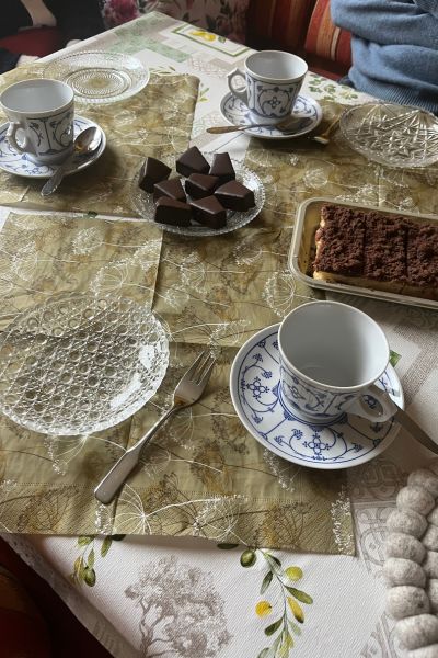 12 von 12 im Oktober 2025; Tisch gedeckt mit blau weißen Kaffeetassen, Glastellern, Baumkuchenecken und Zupfkuchen