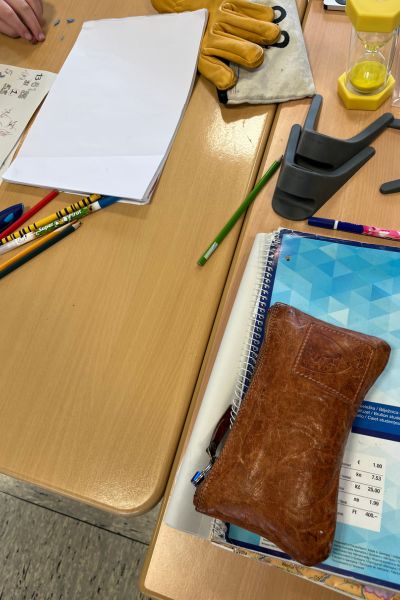 Organisationstipps für Schule und Lernen: Ein Schülertisch mit einem Arbeitsblatt, mehreren Stiften und Arbeitsmaterialien durcheinander auf dem Tisch