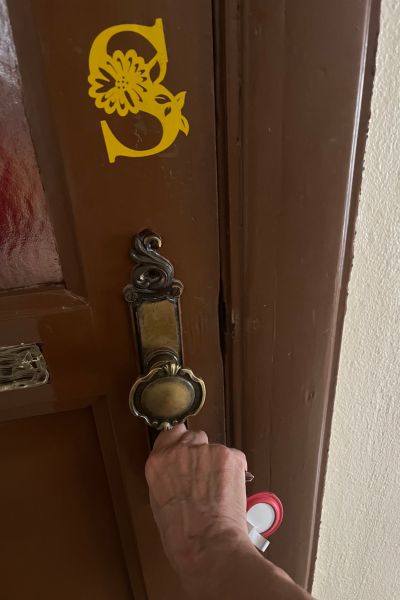 12 von 12 im November 2025: Teil einer Wohnungstür mit Türschloss; Schlüssel steckt im Schlüsselloch und wird von einer Hand gehalten