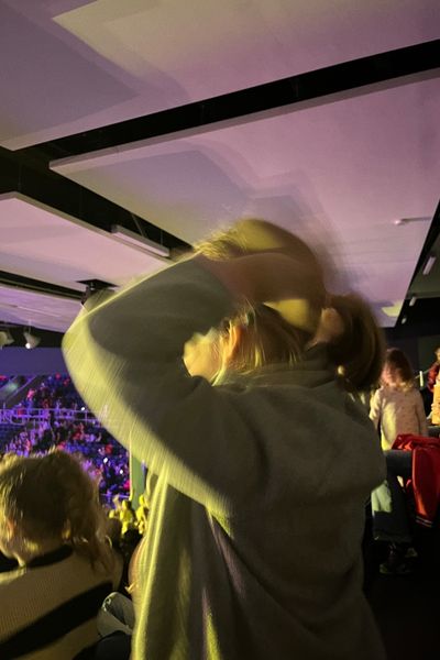 Mädchen in grüner Jacke steht mit dem Blick gerichtet zur Bühne bei Bibi und Tina