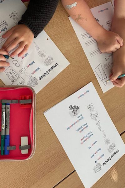 Lerncoaching Familiencoaching KinFlex®; auf dem Tisch liegen Leseblätter; Kinder erlesen sich erste Wörter