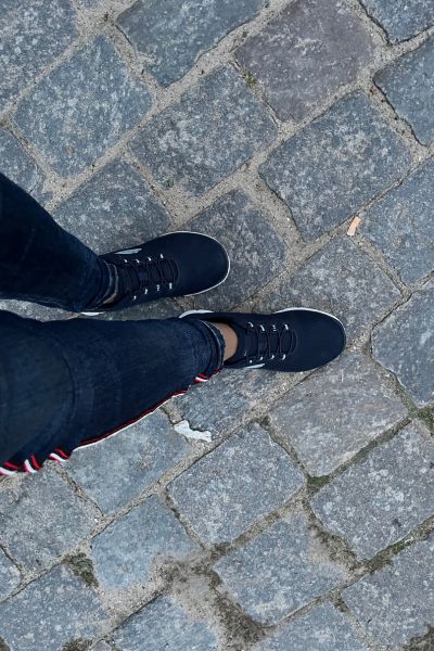 Lerncoaching Familiencoaching KinFlex®; Füße in blauen Sneakern auf dem Asphalt