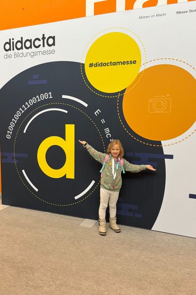 Jahresrueckblick 2025: Mädchen steht vor der Leinwand mit der Aufschrift didacta