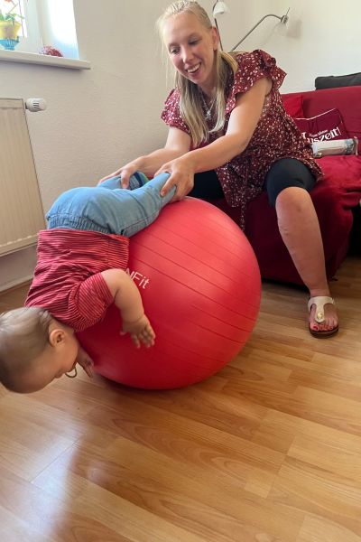Lernen mit ADHS: Kleinkind liegt auf großem Gymnastikball