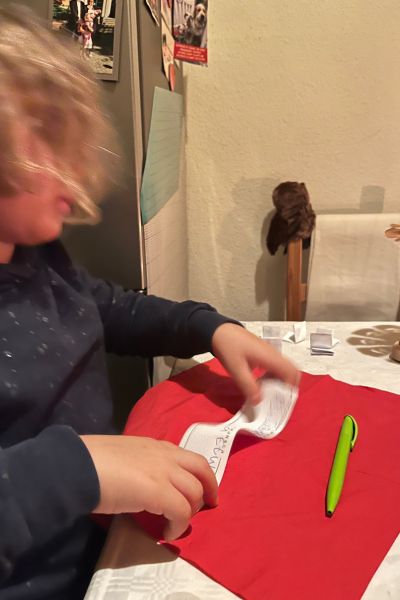 Konzentrationsprobleme bei Kindern: Kind schreibt auf roter Unterlage