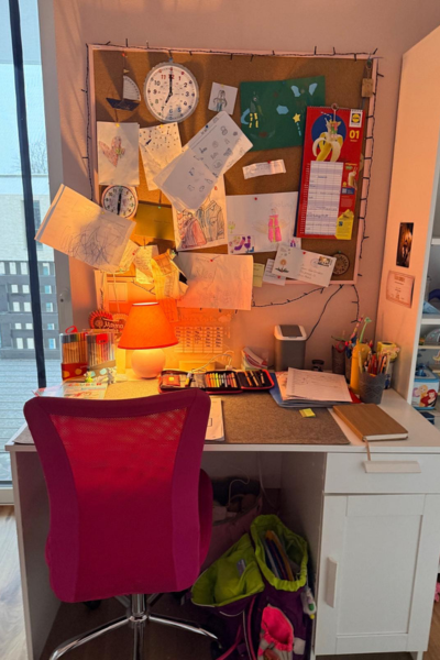 Lerncoaching bei ADHS: aufgeräumter Schreibtisch mit pinkfarbenen Schreibstuhl davor, große Pinnwand mit vielen Zetteln an der Wand