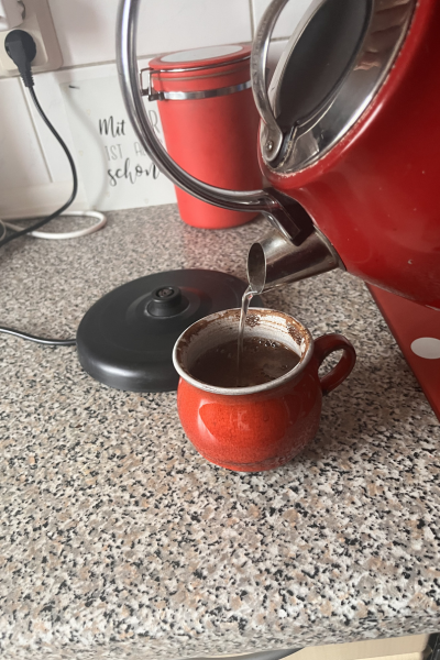 12 von 12 im April 2026: Kaffeewasser wird aus rotem Teekessel aufgegossen