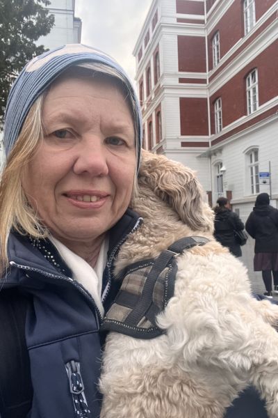 12 von 12 im Mai 2026: Porträt einer Frau mit Mütze hält einen Bolonka Zwetna im Arm