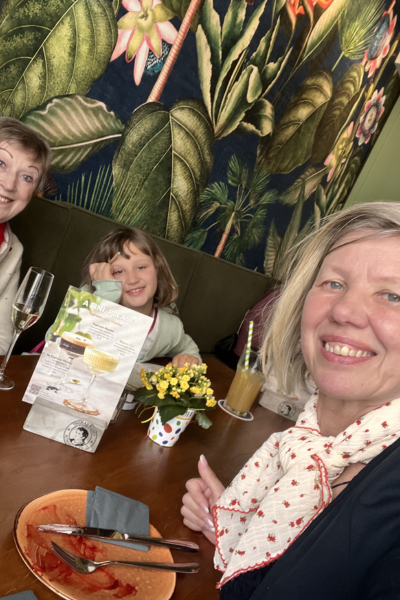 Lernen und Familie: zwei Frauen und ein Mädchen am Tisch in einer Gaststätte