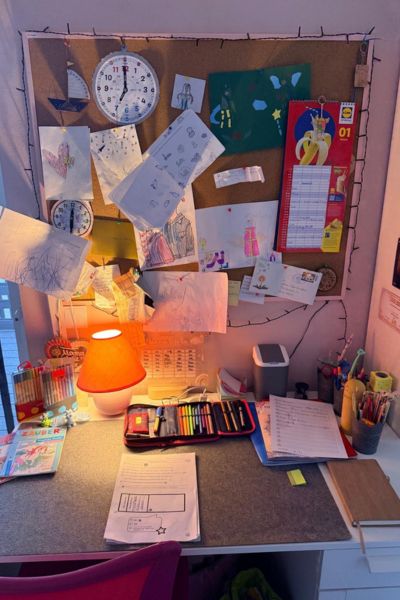 kind-kann-sich-nicht-konzentrieren: Schreibtisch eines Kindes mit Pinnwand im Hintergrund
