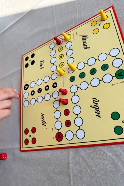 Spiele für Konzentration: Mensch ärgere dich nicht Spiel mit Spielfiguren darauf auf dem Tisch