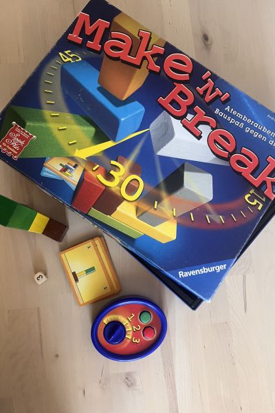 Spiele für Konzentration: Mak'n break Spielkarton, Spielkarten, Uhr, Würfel und Bausteinen auf dem Tisch