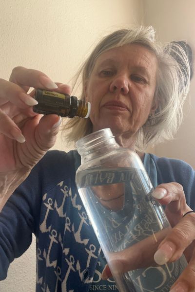 Energie statt Erschöpfung: Porträt einer Frau mit einer Wasserflasche und einer Flasche ätherischem Öl Limette