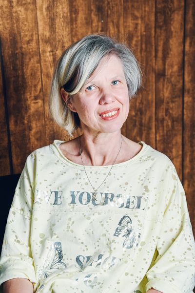 mein Mathematiklehrer: blonde Frau im gelben T-Shirt schaut nachdenklich und freundlich
