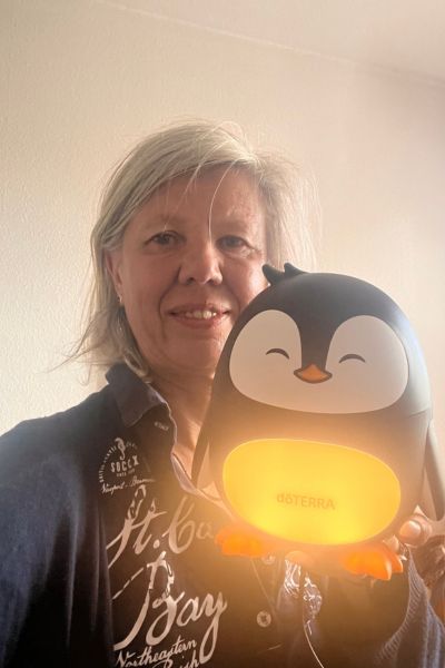 12 von 12 im August 2026: Frau Mitte fünfzig halt einen Pinguin Diffuser von doterra in der Hand, dessen Bauch leuchtet