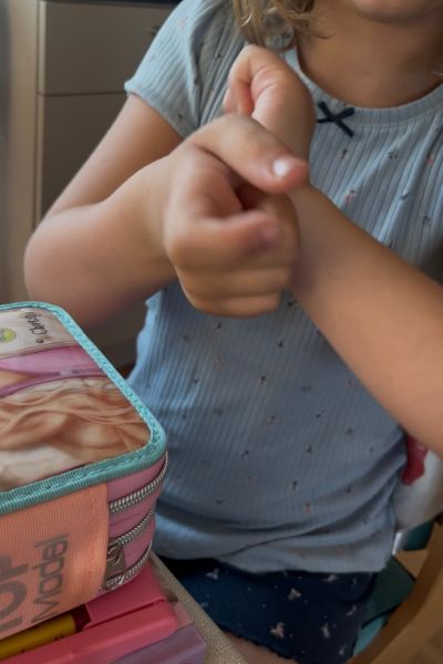 Ätherische Öle für Kinder: Kind verteilt eine ätherische Ölmischung auf die Pulspunkte auf den Armen