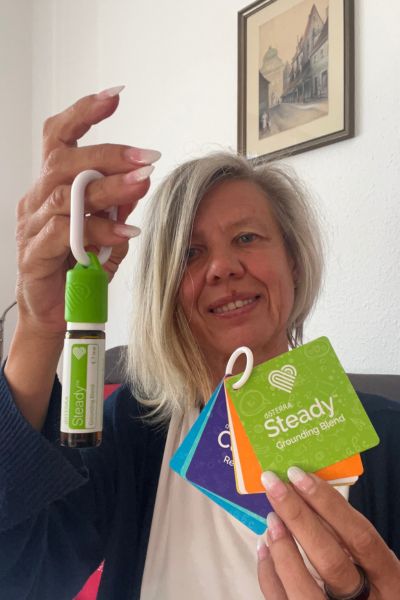 Hausaufgaben ohne Stress: blonde Frau zeigt das ätherische Öl Steady aus der Kids Collection von doTerra