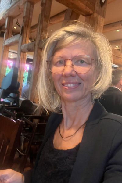 12 von 12 im September 2026: blonde Frau mit mittellangen Haaren in blauem Blazer schaut lächelnd nach vorne