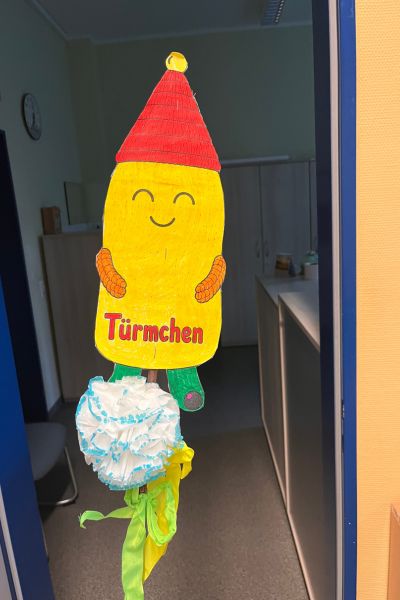 Monatsrückblick Oktober 2026: Schulmaskottchen Türmchen: Türmchen mit rotem Dach uns Schriftzug Türmchen
